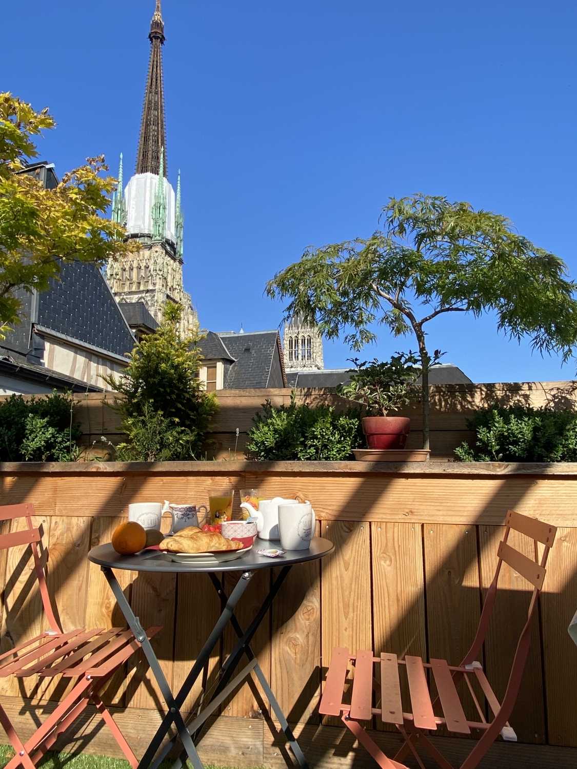 Terrasse privée du studio de l’Hôtel de la Cathédrale à Rouen, avec petit-déjeuner servi face à la flèche gothique.